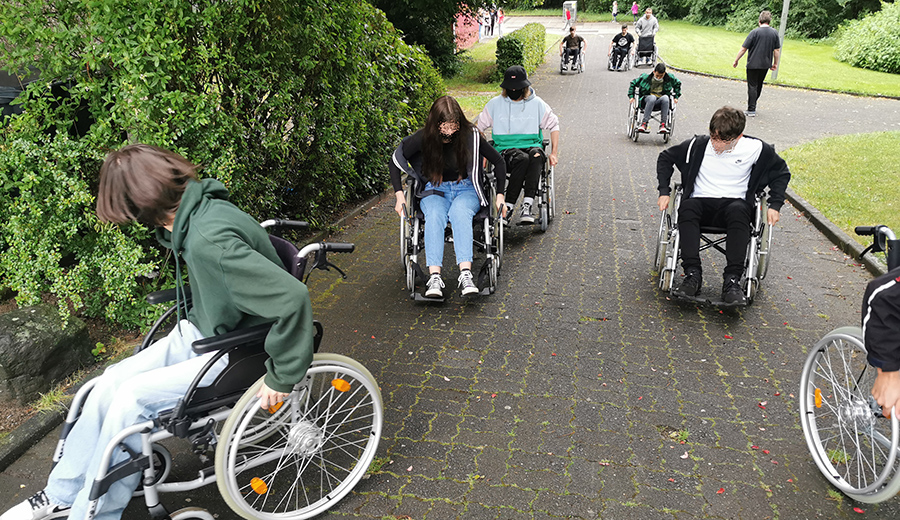 Mit Taststock und Rollstuhl auf dem Schulhof