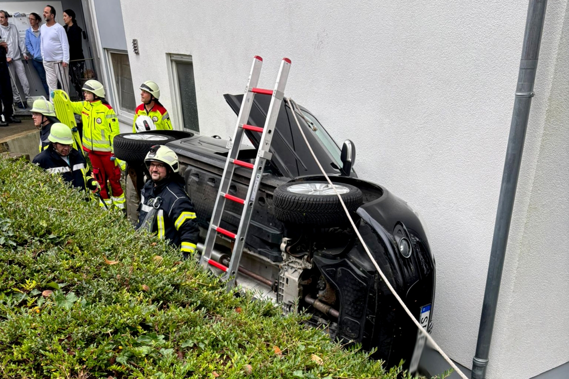 Pkw landet nach Fahrt über eine Mauer auf der Seite