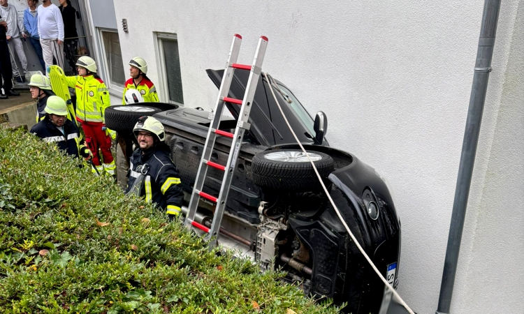 Pkw landet nach Fahrt über eine Mauer auf der Seite