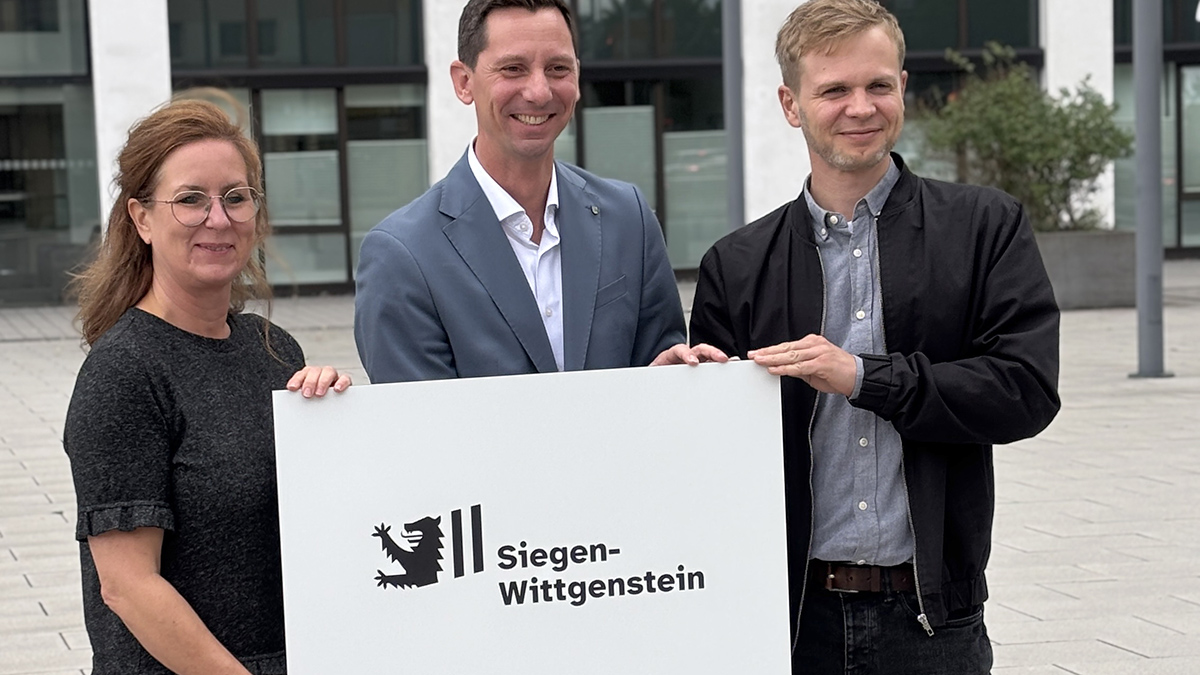 Yvonne Müller (KD1), Landrat Andreas Müller und Jakob Schneider (KD1) präsentieren das neue Logo des Kreises, das ab dem 1. Oktober schrittweise eingeführt wird.   